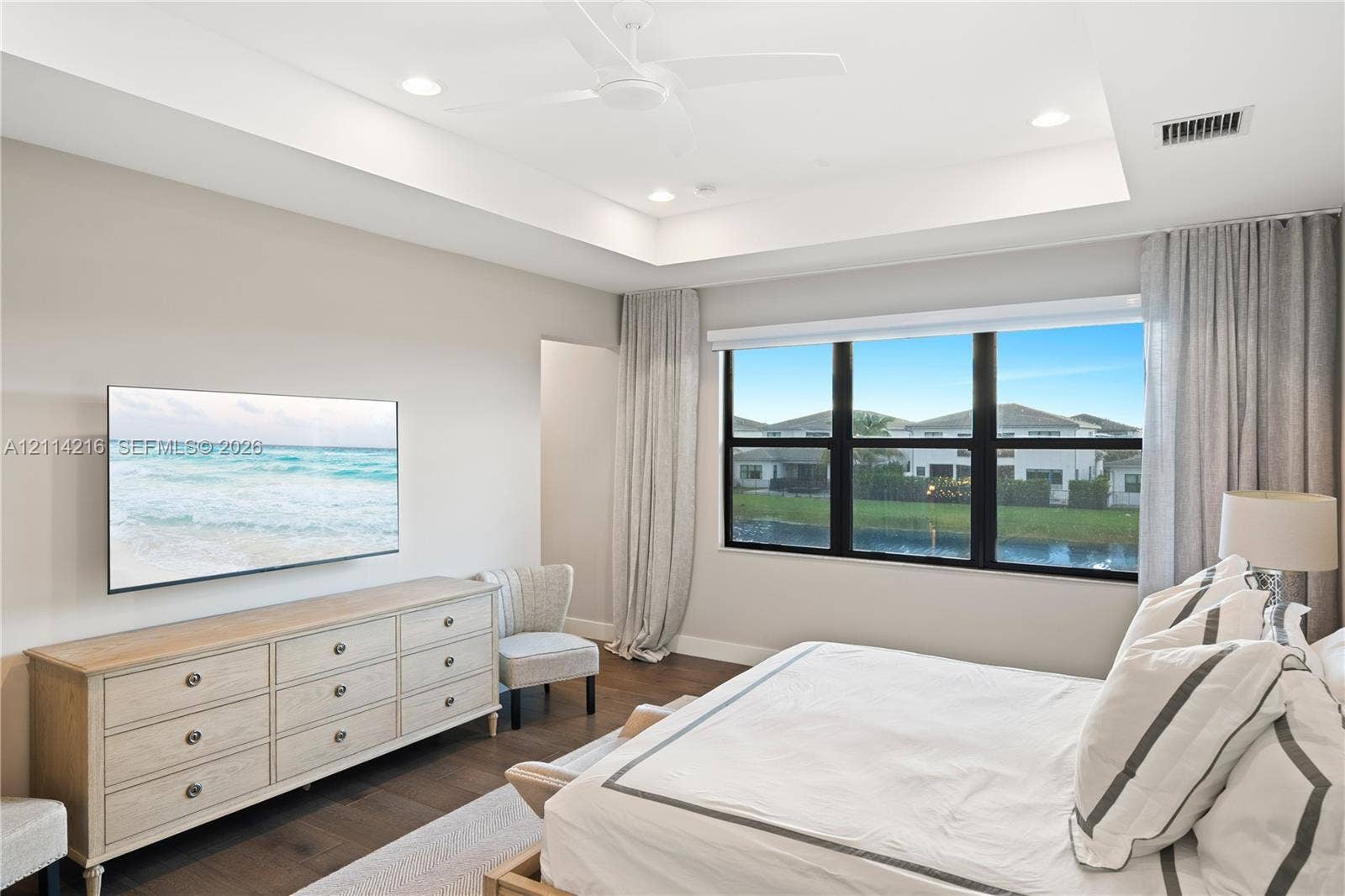 17085 Teton River Road, Boca Raton, FL 33496 Tray ceiling with recessed lighting and a central ceiling fan, large windows with dark frames, and wood-finish flooring