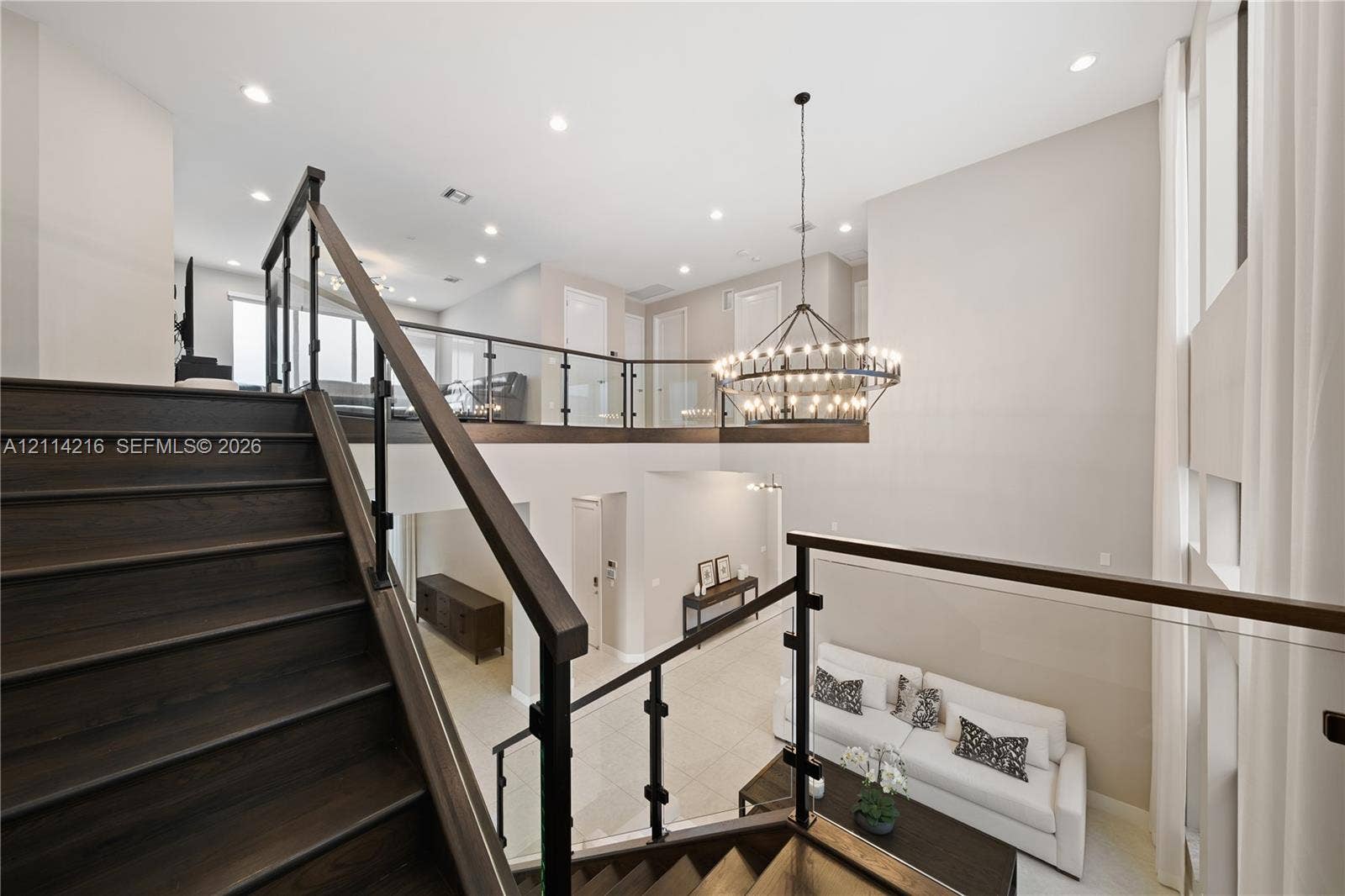17085 Teton River Road, Boca Raton, FL 33496 Staircase with wood-finish treads, dark railings, and glass panels