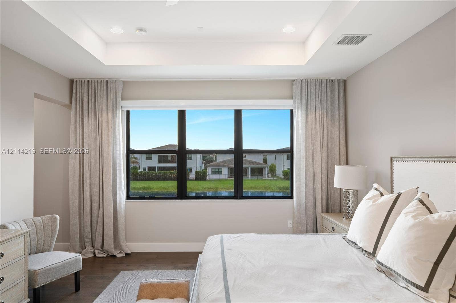 17085 Teton River Road, Boca Raton, FL 33496 Tray ceiling with integrated recessed lighting and large windows featuring black frames and wood-finish flooring