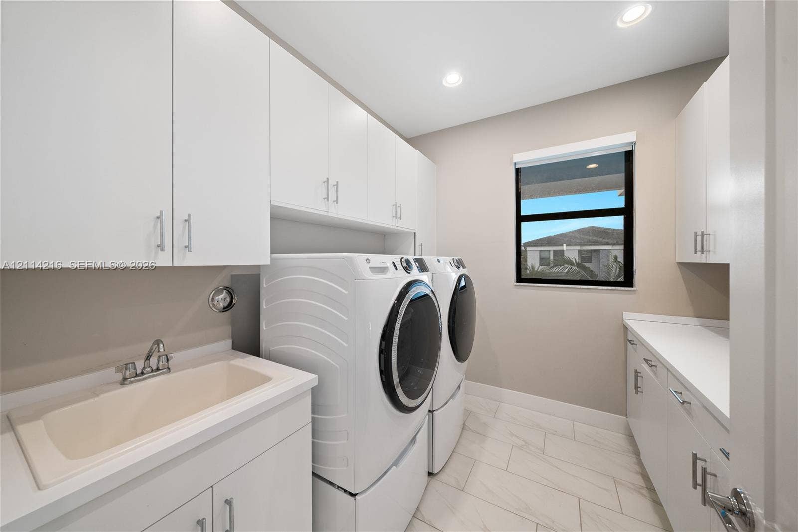 17085 Teton River Road, Boca Raton, FL 33496 Laundry room featuring white cabinetry, a composite utility sink, quartz countertops, recessed lighting, and tile flooring