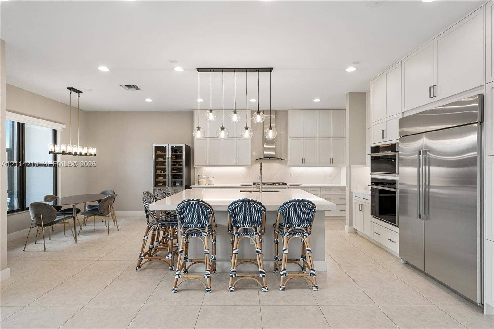 17085 Teton River Road, Boca Raton, FL 33496 Kitchen featuring flat-panel cabinetry, a central island with a quartz countertop, professional-grade stainless steel appliances, a built-in wine refrigerator, and multi-light pendant fixtures