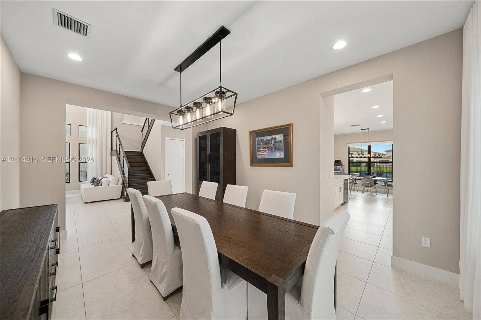 17085 Teton River Road, Boca Raton, FL 33496 Dining area featuring oversized tile flooring, recessed lighting, and a multi-light linear pendant fixture, including a built-in floor-to-ceiling cabinet with glass-front detailing