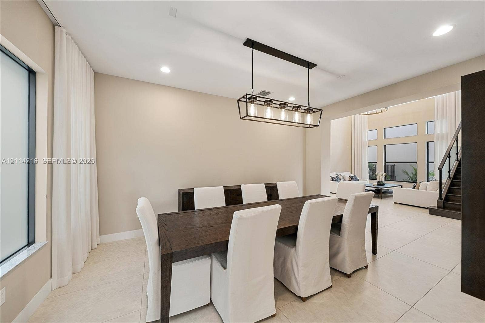 17085 Teton River Road, Boca Raton, FL 33496 Open-concept interior featuring light-toned tile flooring, recessed ceiling lighting, and a linear multi-bulb metal chandelier