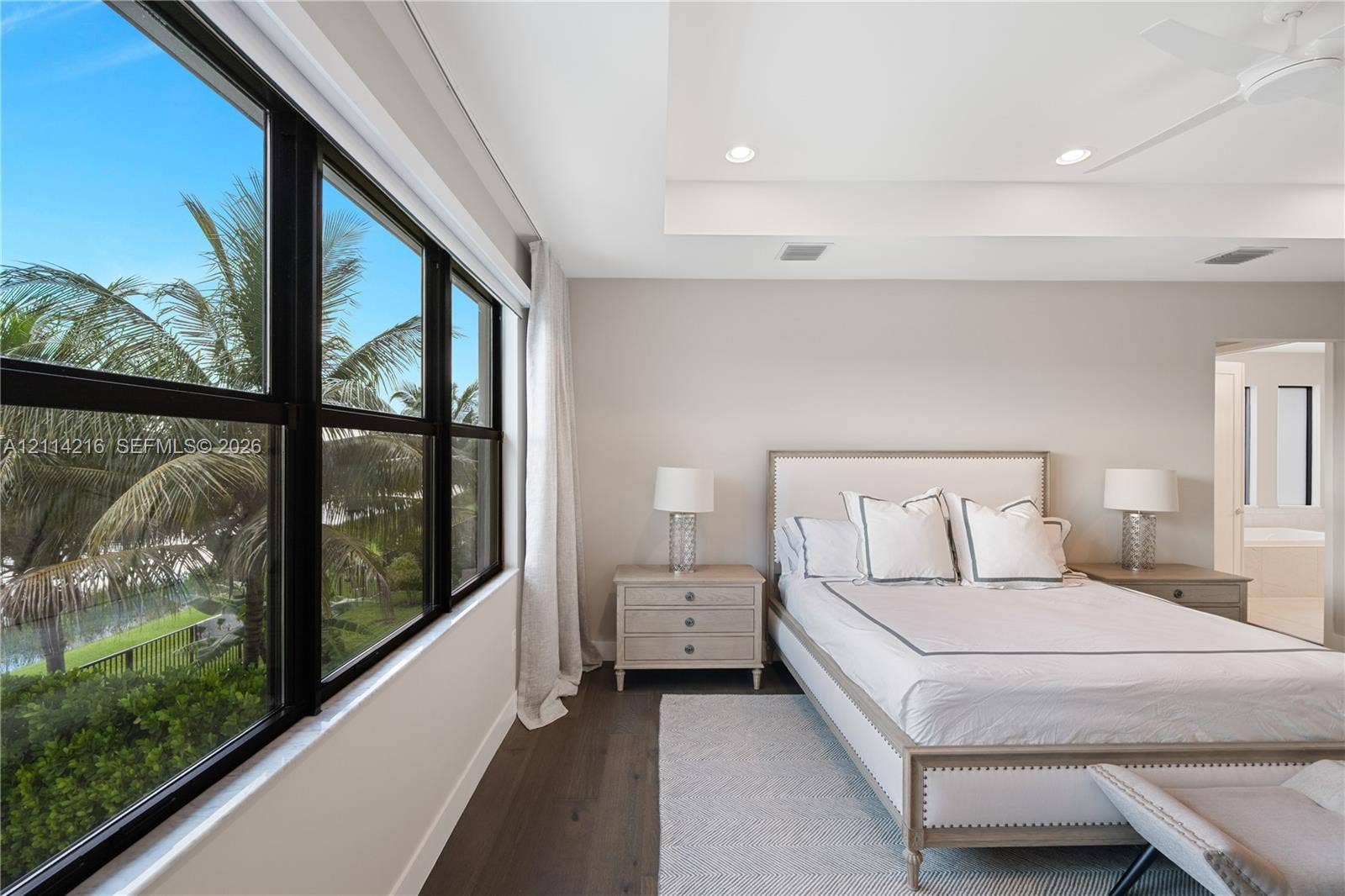 17085 Teton River Road, Boca Raton, FL 33496 Large windows with black frames, tray ceiling with recessed lighting, and dark wood-finish flooring