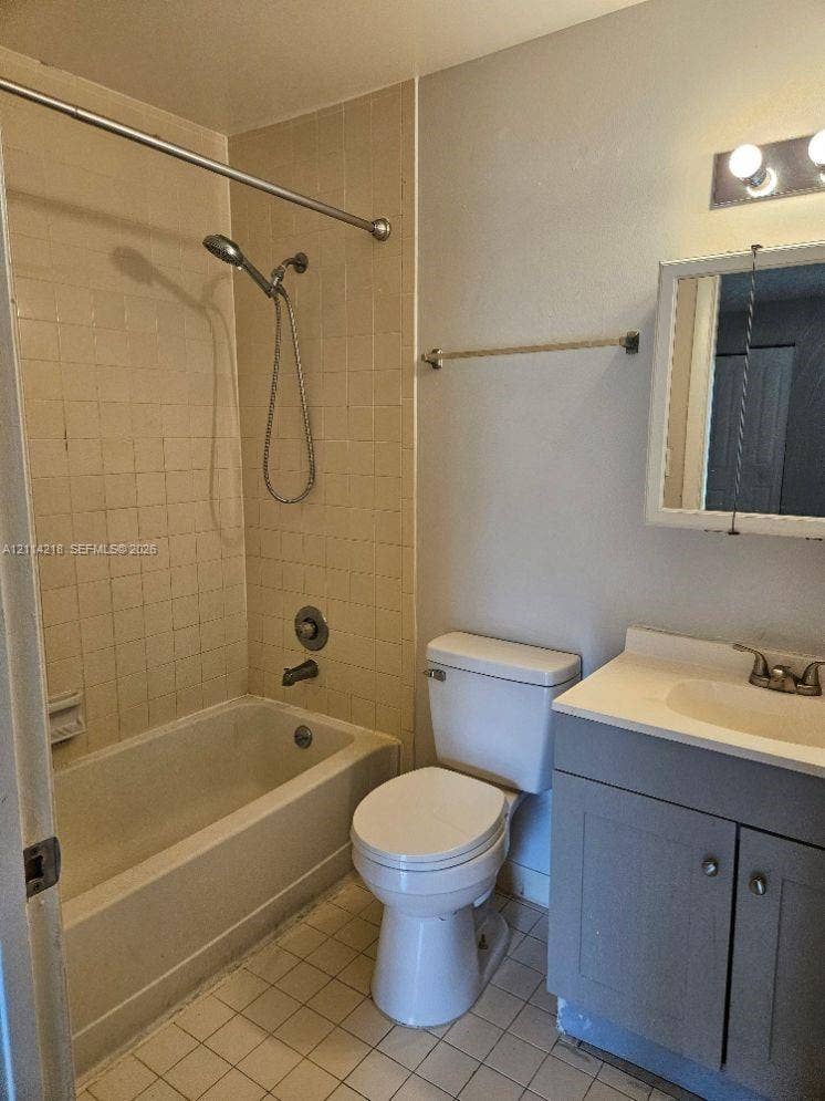 1116 Meadows Circle, #1116, Boynton Beach, Boynton Beach, FL 33436 Bathroom featuring a built-in vanity with a stone-top sink, ceramic tile flooring, a porcelain tub, and a shower-head fixture with integrated controls