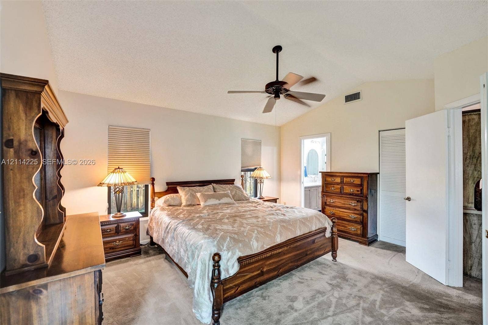 5741 SW 88th Terrace, Cooper City, FL 33328 Vaulted ceiling with a centrally mounted ceiling fan, neutral wall-to-wall carpeting, and louvered closet doors