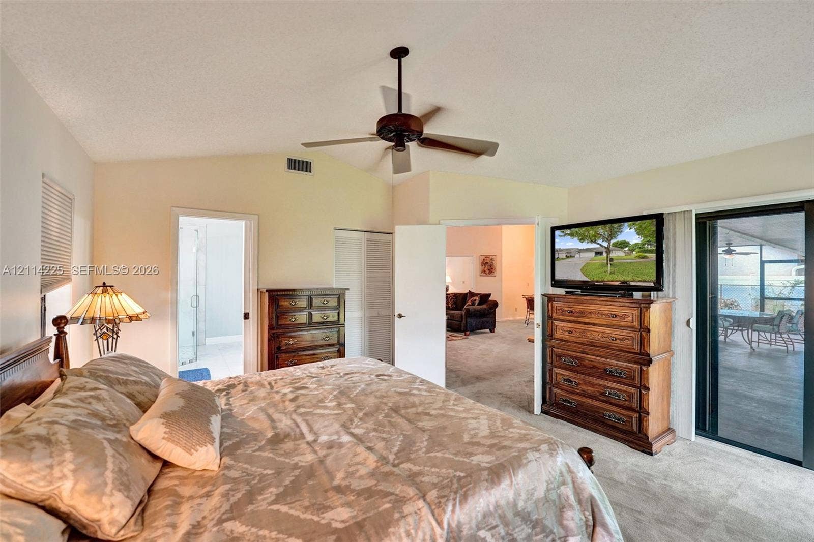 5741 SW 88th Terrace, Cooper City, FL 33328 Vaulted ceiling featuring a central blade-style ceiling fan and sliding glass doors providing access to the exterior
