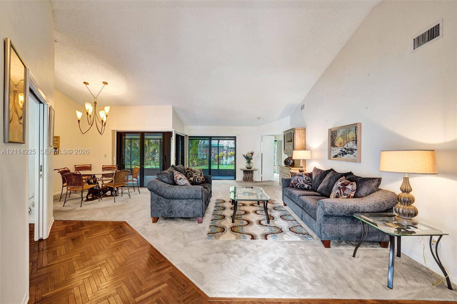 5741 SW 88th Terrace, Cooper City, FL 33328 Vaulted ceilings, parquet wood flooring, and multi-panel sliding glass doors providing outdoor access