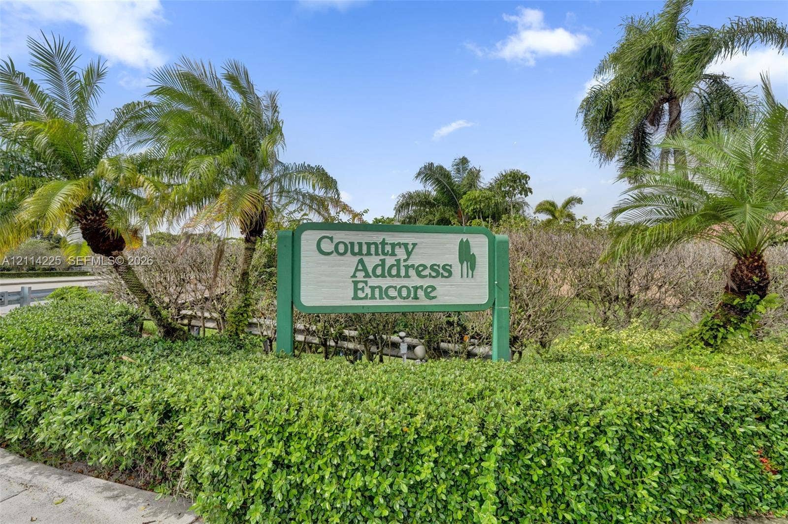 5741 SW 88th Terrace, Cooper City, FL 33328 Community signage featuring professional landscaping, manicured hedges, and mature palm trees