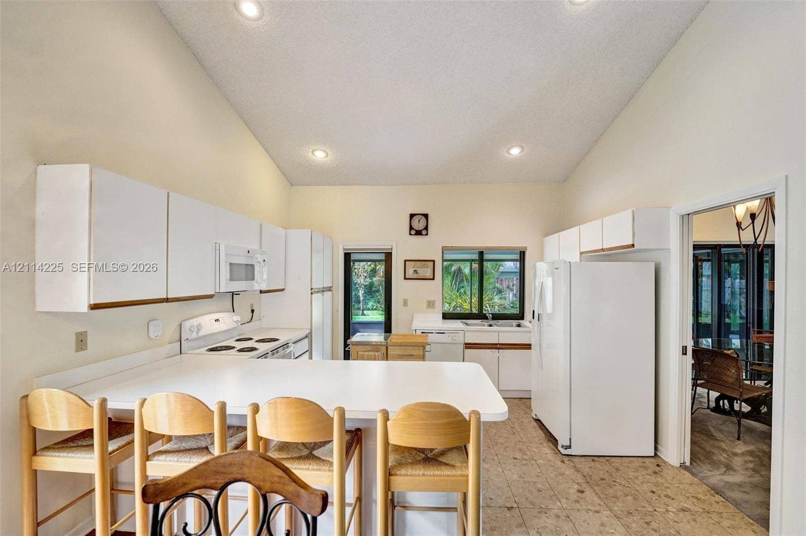 5741 SW 88th Terrace, Cooper City, FL 33328 Kitchen featuring high vaulted ceilings, recessed lighting, white cabinetry, a breakfast bar, and tile flooring