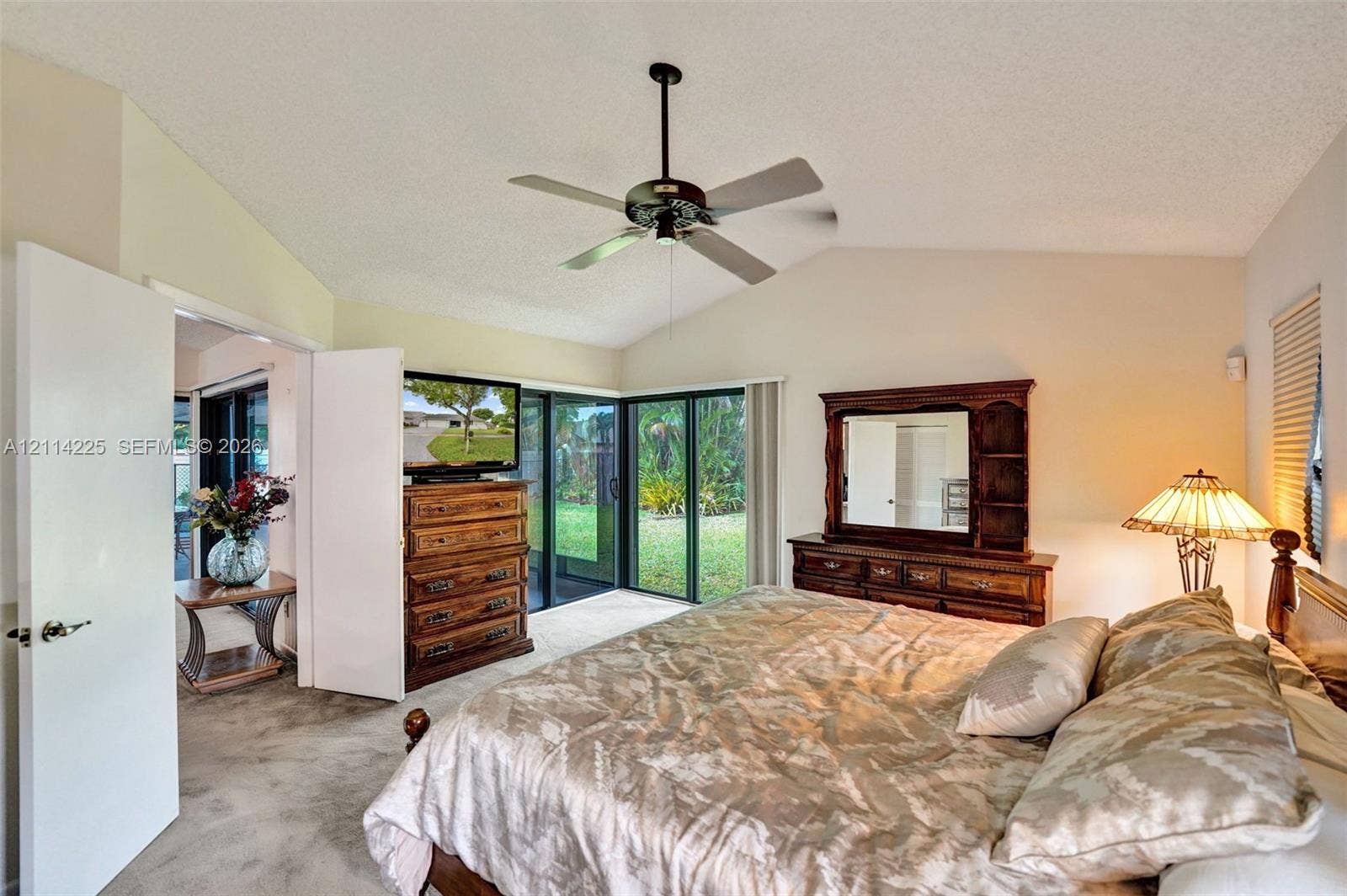 5741 SW 88th Terrace, Cooper City, FL 33328 Vaulted ceilings featuring a centrally mounted ceiling fan and sliding glass doors providing external access