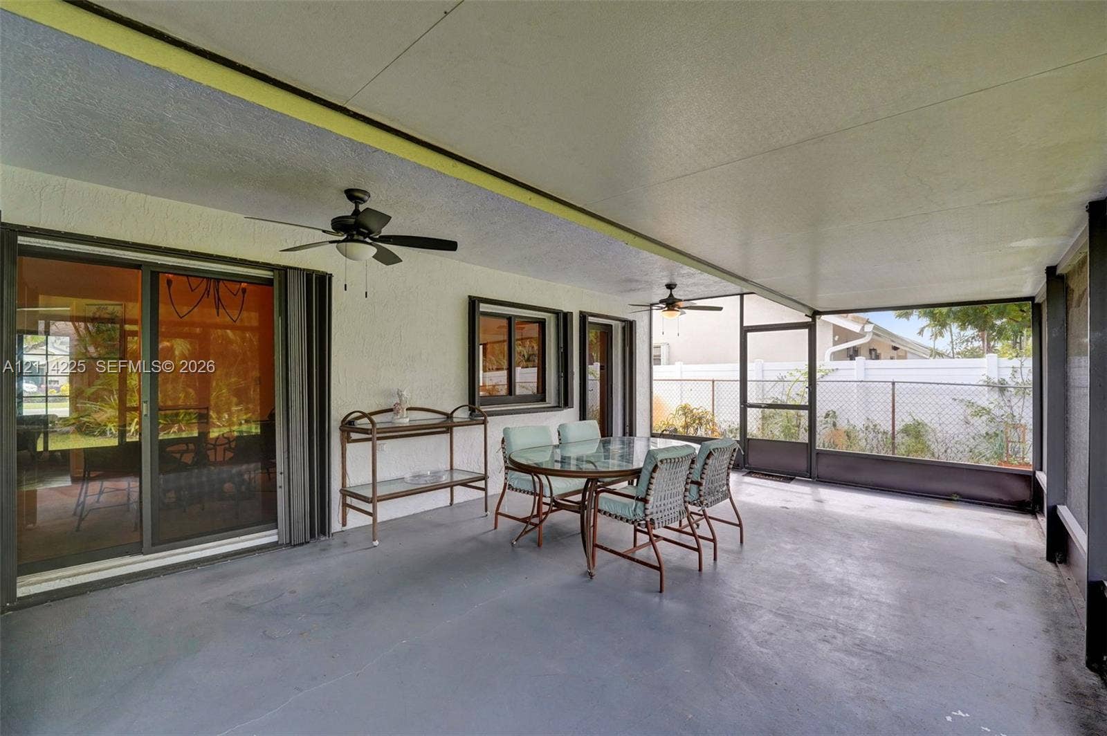 5741 SW 88th Terrace, Cooper City, FL 33328 Covered lanai featuring a concrete floor, two ceiling fans, and a screened-in enclosure