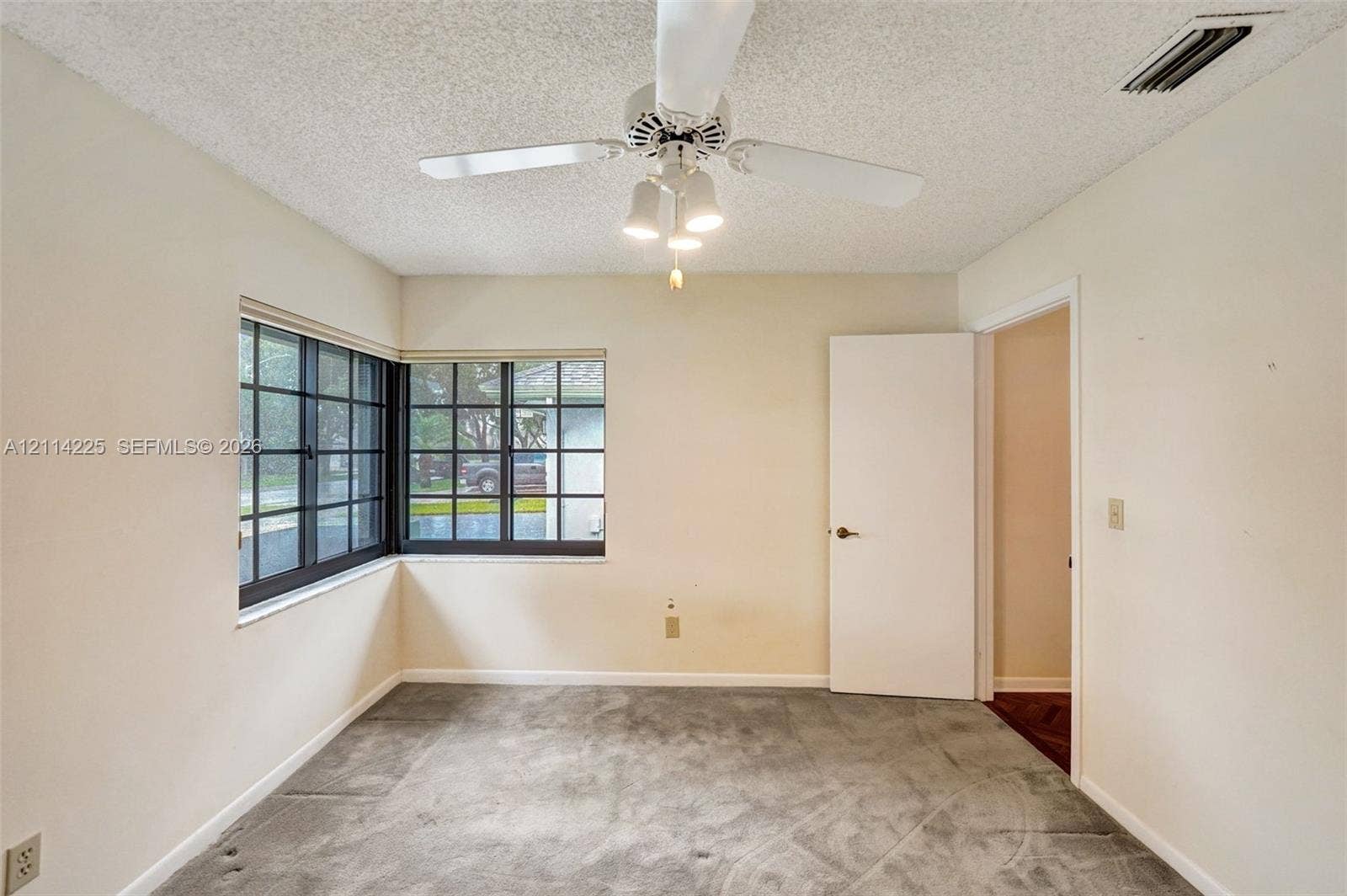 5741 SW 88th Terrace, Cooper City, FL 33328 Corner windows with dark-finish frames, neutral wall finishes, and a central ceiling fan with integrated lighting