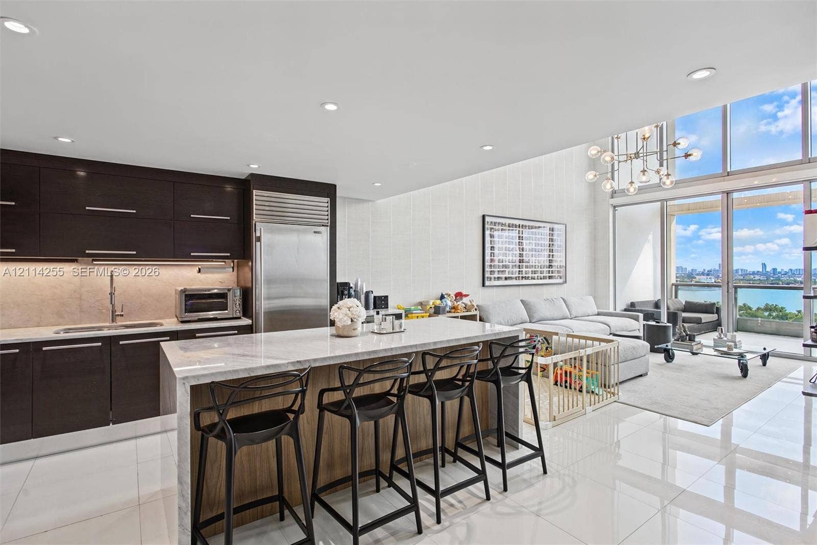 900 Biscayne Boulevard, #1705, Miami, FL 33132 Kitchen featuring dark custom cabinetry, stone-topped waterfall island, professional-grade stainless steel refrigerator, recessed lighting, and floor-to-ceiling windows