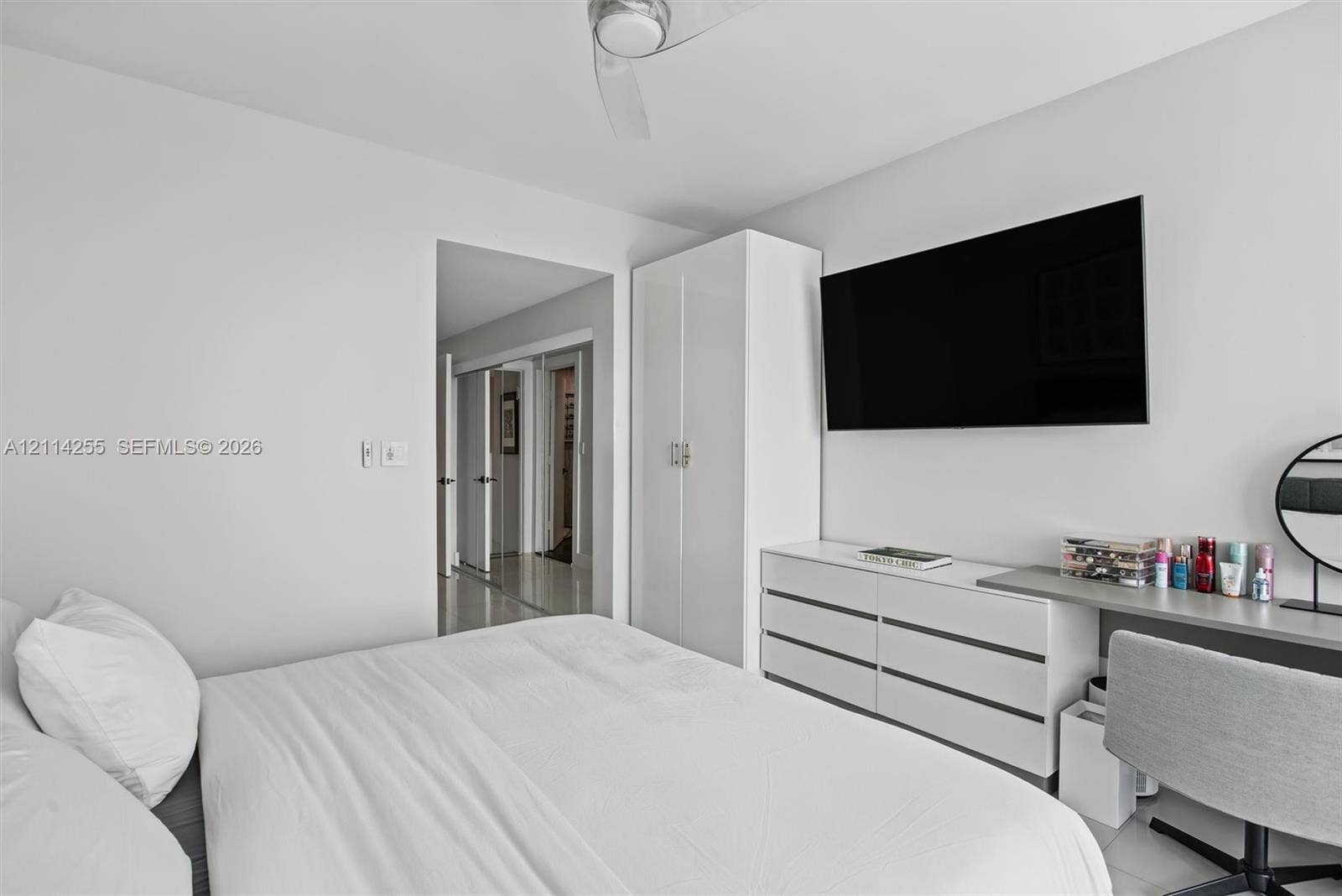 900 Biscayne Boulevard, #1705, Miami, FL 33132 Room interior featuring high-gloss white built-in cabinetry, smooth-finish ceilings with a central fan, and neutral flooring