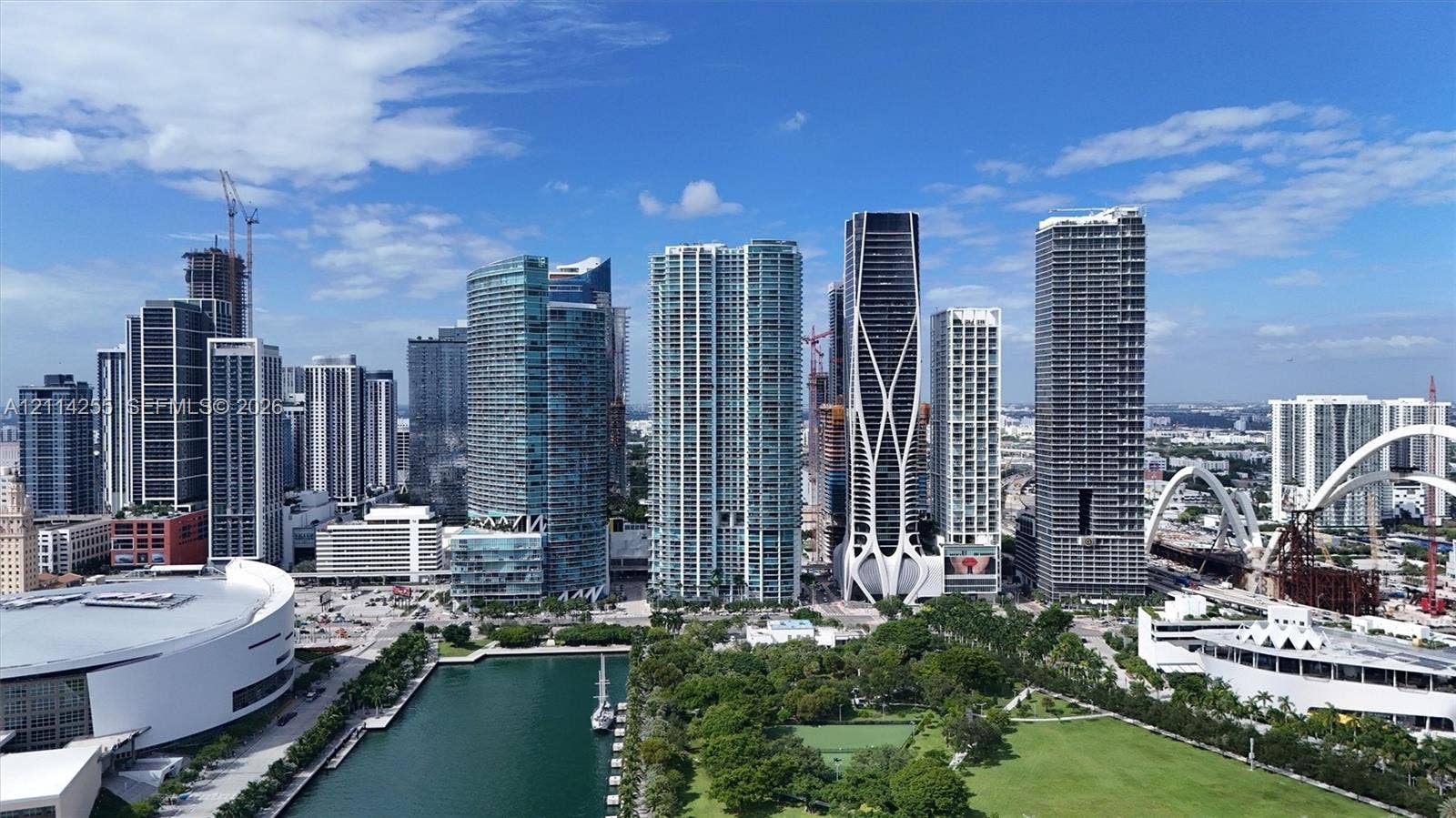 900 Biscayne Boulevard, #1705, Miami, FL 33132 Aerial perspective of an urban center featuring high-rise glass-facade towers, manicured green space, and a waterfront basin