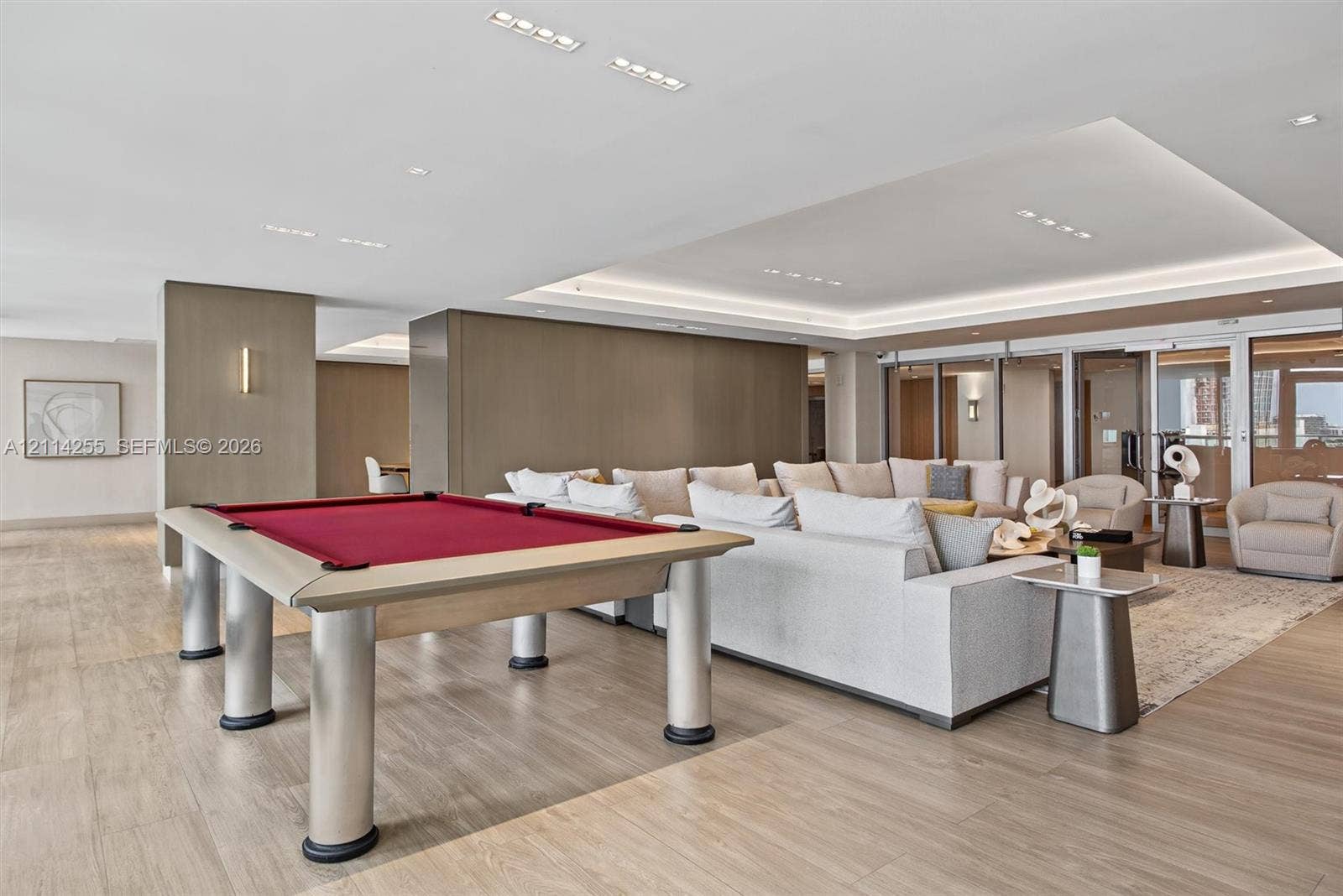 900 Biscayne Boulevard, #1705, Miami, FL 33132 Open-concept interior featuring recessed ceiling lighting, tray ceiling detail with perimeter cove lighting, wood-finish flooring, and floor-to-ceiling glass panel doors
