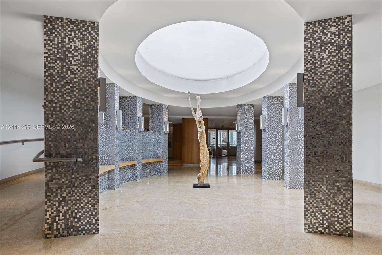 900 Biscayne Boulevard, #1705, Miami, FL 33132 Circular rotunda featuring a recessed dome ceiling, mosaic-tiled structural columns, built-in wooden benches, and polished stone flooring
