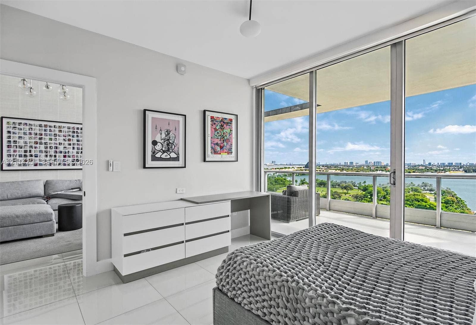 900 Biscayne Boulevard, #1705, Miami, FL 33132 Floor-to-ceiling glass sliding doors, private balcony with metal railing, white tile flooring, and clean-lined interior finishes