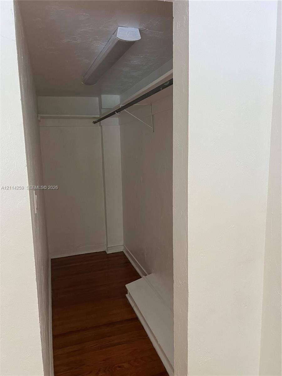1895 SW 22nd, #5, Miami, Miami, FL 33145 Closet featuring wood-finish flooring, a built-in clothing rod, a white shelf, and a flush-mount ceiling light fixture