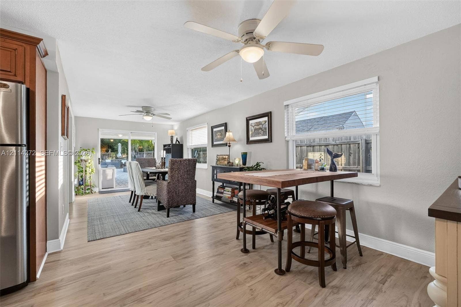 110 Cunningham, New Smyrna Beach, FL 32168 Open-concept area featuring wood-finish flooring, dual ceiling fans, stainless steel appliances, and a sliding glass door