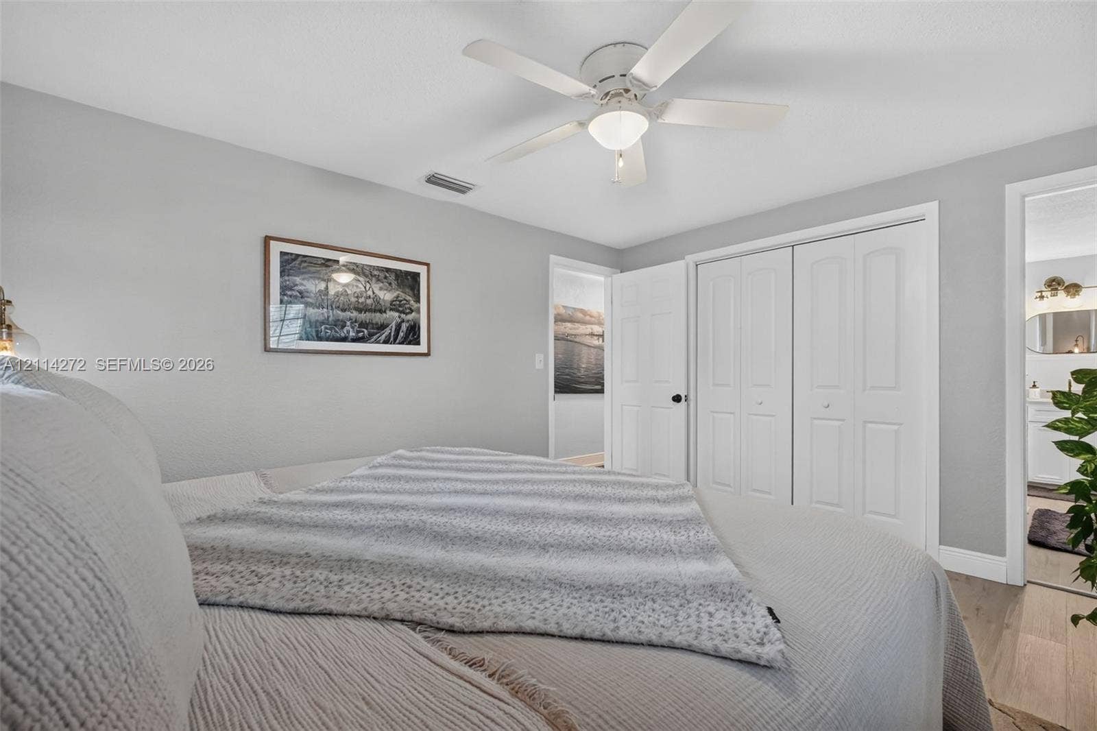 110 Cunningham, New Smyrna Beach, FL 32168 Neutral-toned room featuring a central ceiling fan with an integrated light fixture, light wood-finish flooring, and double-panel closet doors