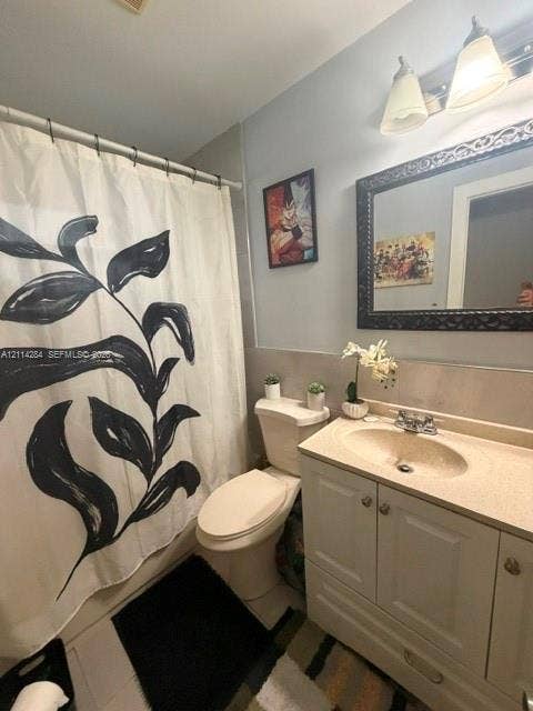2312 Van Buren Street, #10, Hollywood, FL 33020 Bathroom featuring a white vanity cabinet with an integrated sink and countertop, two-light fixture, and a framed mirror