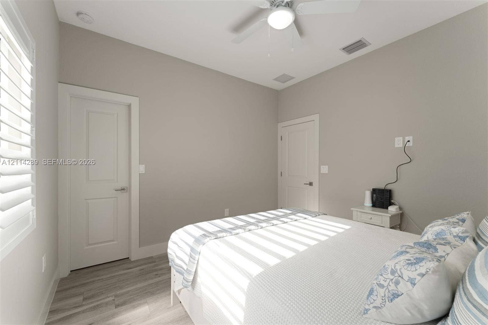 646 Cabrera Street, Key Largo, FL 33037 Neutral interior featuring wood-finish flooring, two-panel interior doors, plantation shutters, and a ceiling fan with integrated lighting