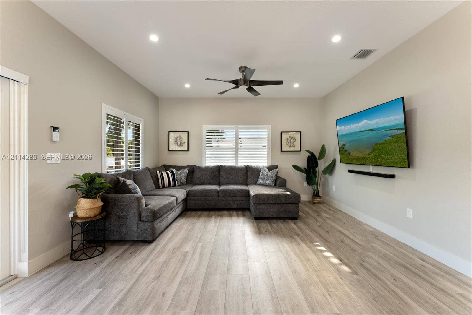 646 Cabrera Street, Key Largo, FL 33037 Neutral-toned living space featuring wood-finish flooring, recessed lighting, a modern ceiling fan, and plantation shutters
