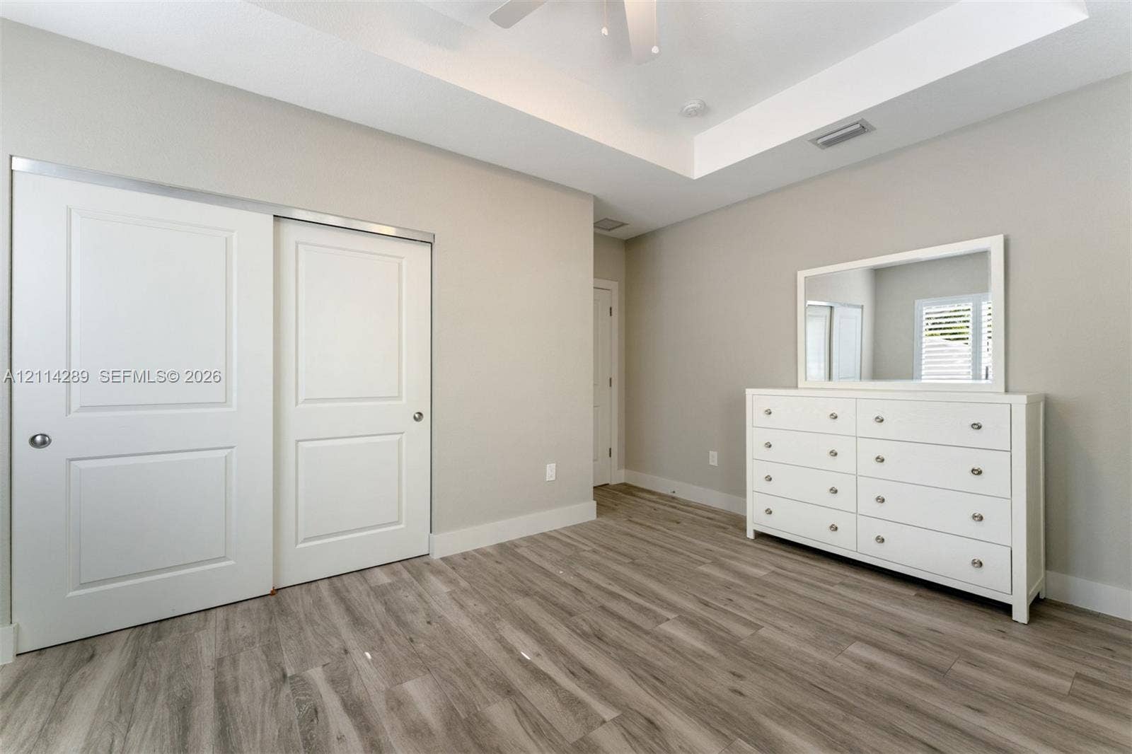 646 Cabrera Street, Key Largo, FL 33037 Tray ceiling, wood-finish flooring, sliding panel closet doors, and recessed lighting