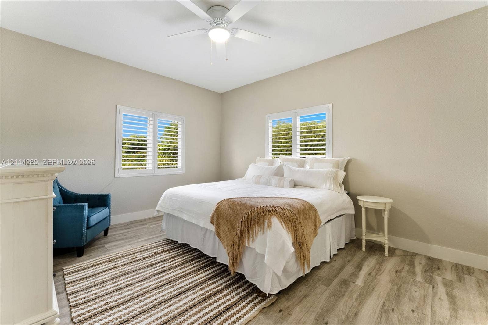 646 Cabrera Street, Key Largo, FL 33037 Room featuring wood-finish flooring, white plantation shutters, and a central ceiling fan with integrated lighting