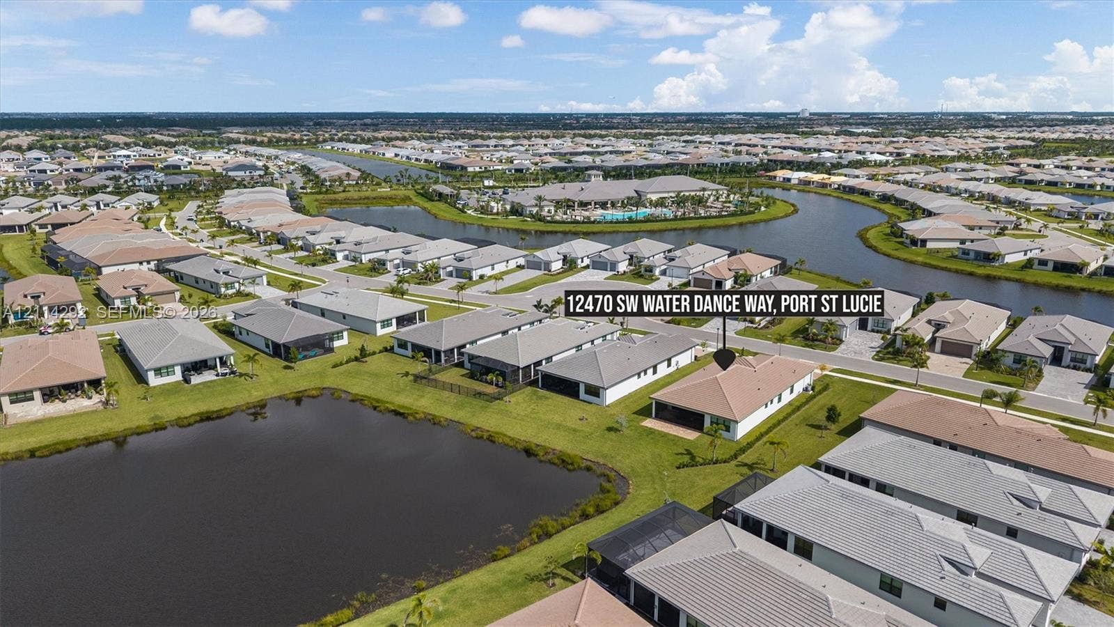 Aerial perspective featuring a single-story residence with a multi-hipped roof, a screened-in rear lanai, and a waterfront position