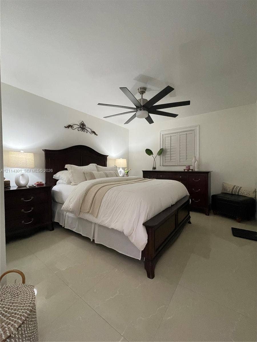 Large-format polished tile flooring, multi-blade ceiling fan with integrated lighting, and plantation shutters