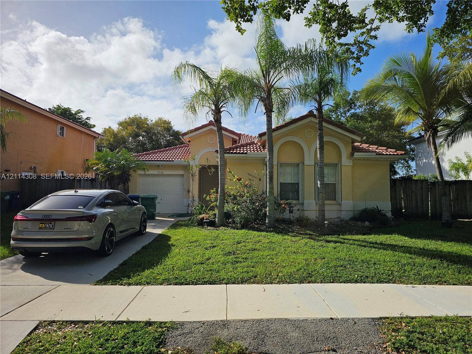 Single-story residence featuring a tile roof, stucco exterior, arched window detailing, and an attached garage