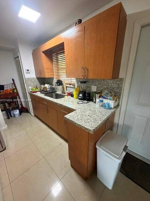 2312 Van Buren Street, #11, Hollywood, FL 33020 Kitchen featuring light-finish wood cabinetry, stone-texture countertops, tile flooring, and a stainless steel undermount sink