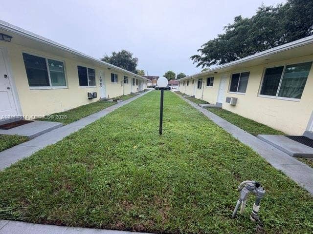 2312 Van Buren Street, #11, Hollywood, FL 33020 Exterior courtyard featuring dual concrete walkways, manicured lawn, and post-mounted globe lighting