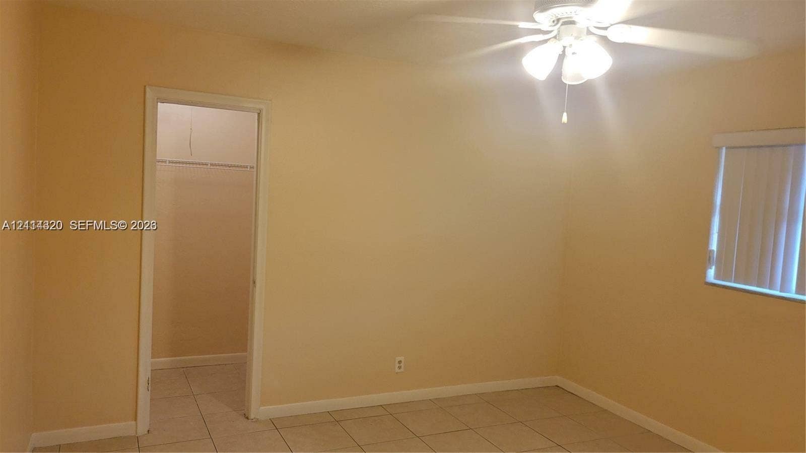 2131 N 19th Avenue, #2133, Hollywood, Hollywood, FL 33020 Neutral interior space featuring tile flooring, a multi-blade ceiling fan with integrated lighting, and a closet with a built-in wire shelf
