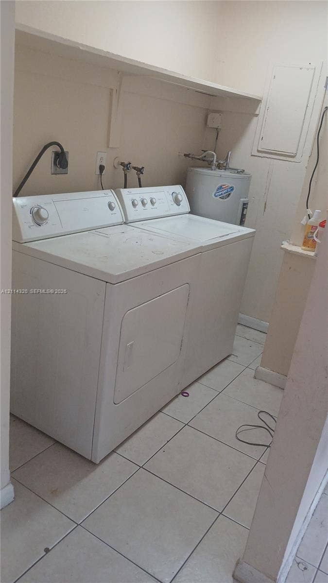 2131 N 19th Avenue, #2133, Hollywood, Hollywood, FL 33020 Utility area featuring ceramic tile flooring, an overhead storage shelf, and dedicated water heater enclosure