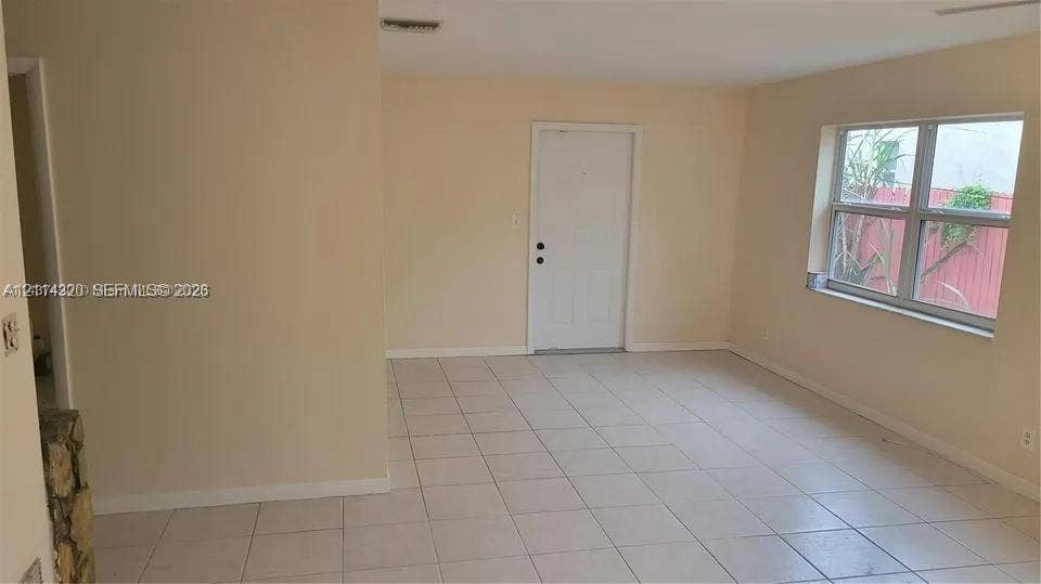 2131 N 19th Avenue, #2133, Hollywood, Hollywood, FL 33020 Neutral-toned interior featuring ceramic tile flooring, a large multi-pane window, and a solid-panel exterior door