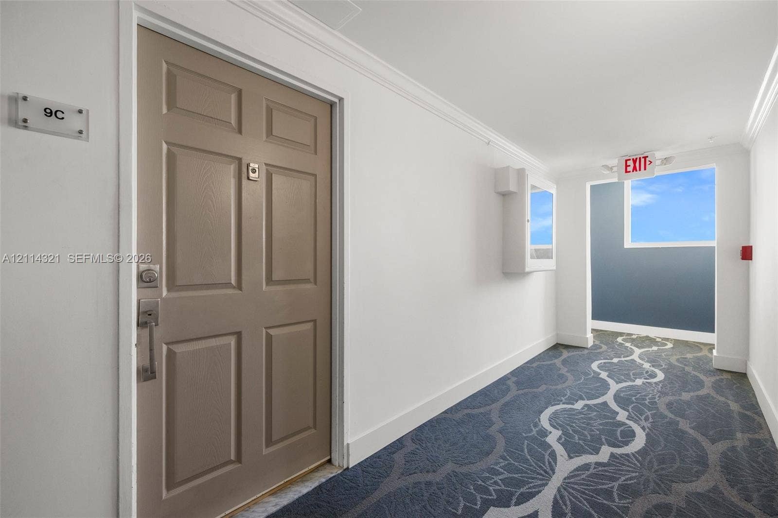 10350 W Bay Harbor Drive, #9C, Bay Harbor Islands, FL 33154 Six-panel entryway door with brushed metal hardware, decorative patterned carpeting, and crown molding