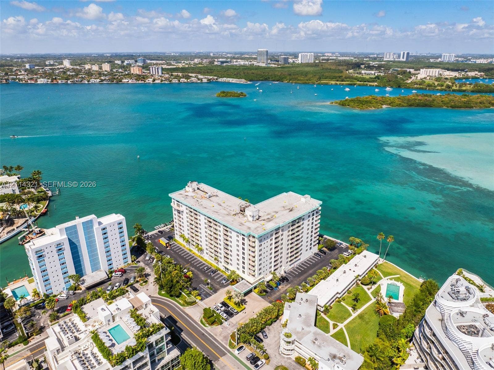10350 W Bay Harbor Drive, #9C, Bay Harbor Islands, FL 33154 Waterfront high-rise building situated on a peninsula, featuring on-site paved parking, manicured landscaping, and immediate proximity to the open bay