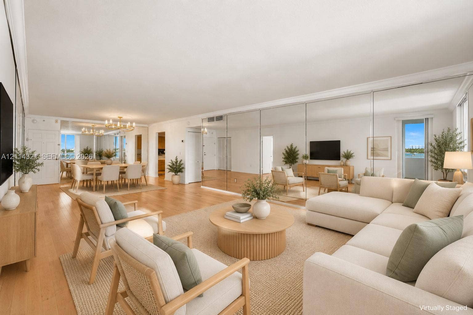 10350 W Bay Harbor Drive, #9C, Bay Harbor Islands, FL 33154 Expansive living area featuring light-toned wood-finish flooring, extensive mirrored wall paneling, and sliding glass doors