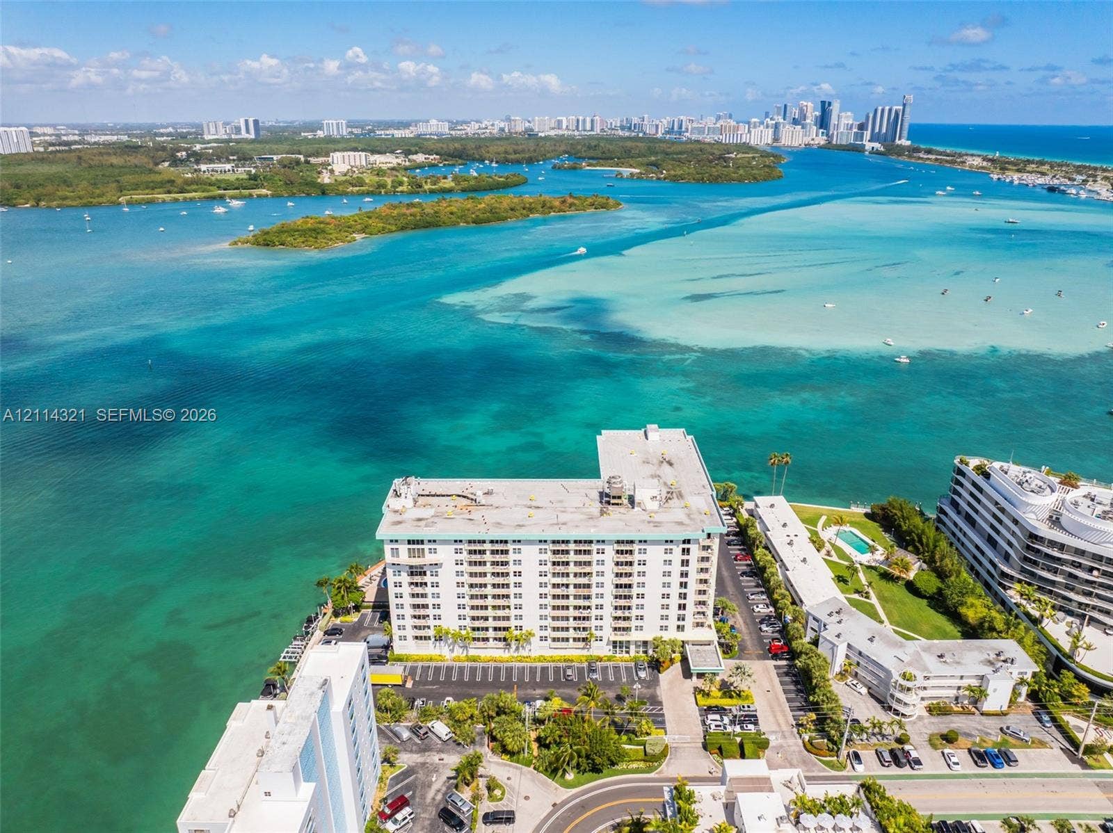 10350 W Bay Harbor Drive, #9C, Bay Harbor Islands, FL 33154 Aerial perspective of a waterfront residential complex featuring expansive coastal surroundings, direct water frontage, and proximity to the open bay