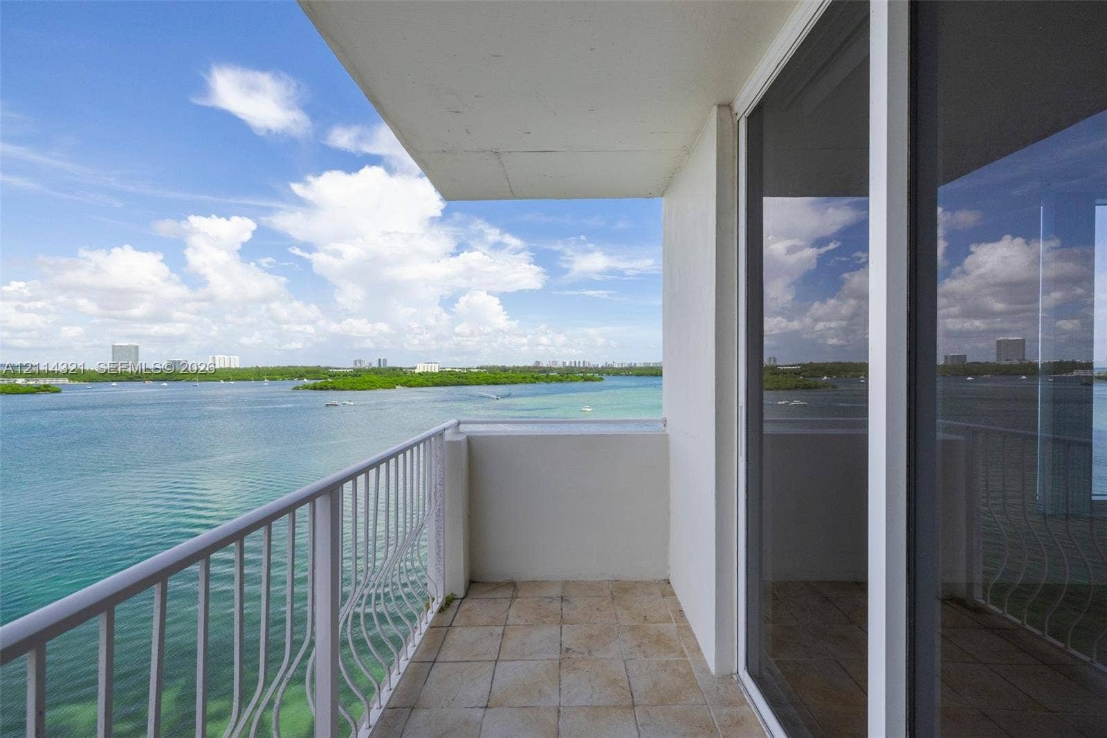10350 W Bay Harbor Drive, #9C, Bay Harbor Islands, FL 33154 Private covered balcony featuring ceramic tile flooring, a white metal railing, and direct water exposure