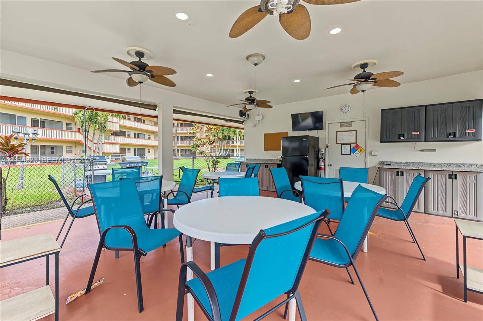 Covered outdoor pavilion featuring built-in cabinetry, recessed lighting, ceiling fans, and stone-finish countertops