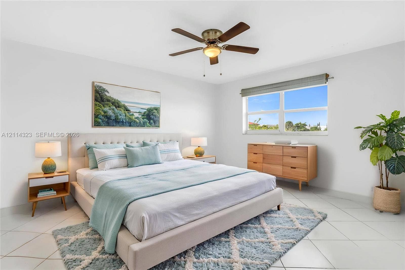 VIRTUALLY STAGED. Bright room featuring neutral wall finishes, tile flooring, a multi-blade ceiling fan with integrated light fixture, and large windows with horizontal blinds