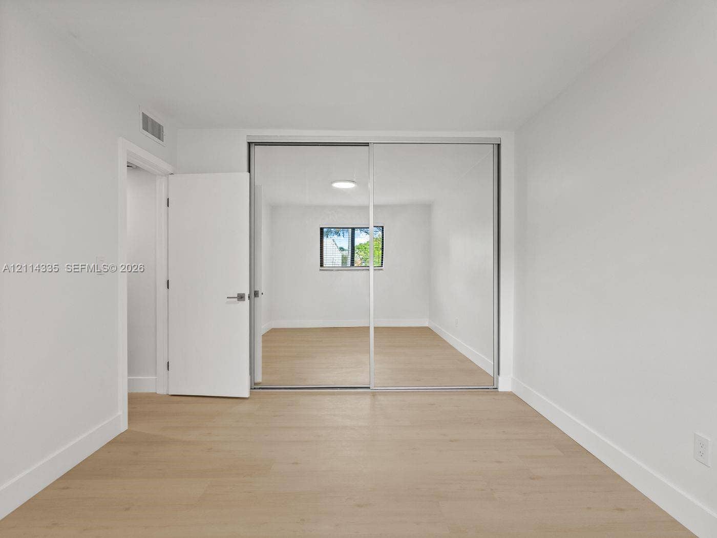 2930 Day Avenue, #N102, Miami, Miami, FL 33133 Light-toned wood-finish flooring, floor-to-ceiling sliding mirror closet doors, flush-mount ceiling lighting, and a single-pane window