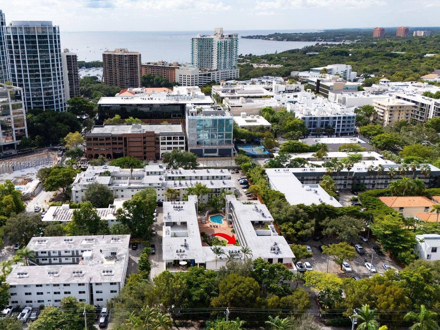 2930 Day Avenue, #N102, Miami, Miami, FL 33133 Aerial perspective of a multi-unit complex featuring an in-ground courtyard swimming pool, mature perimeter landscaping, and surface parking