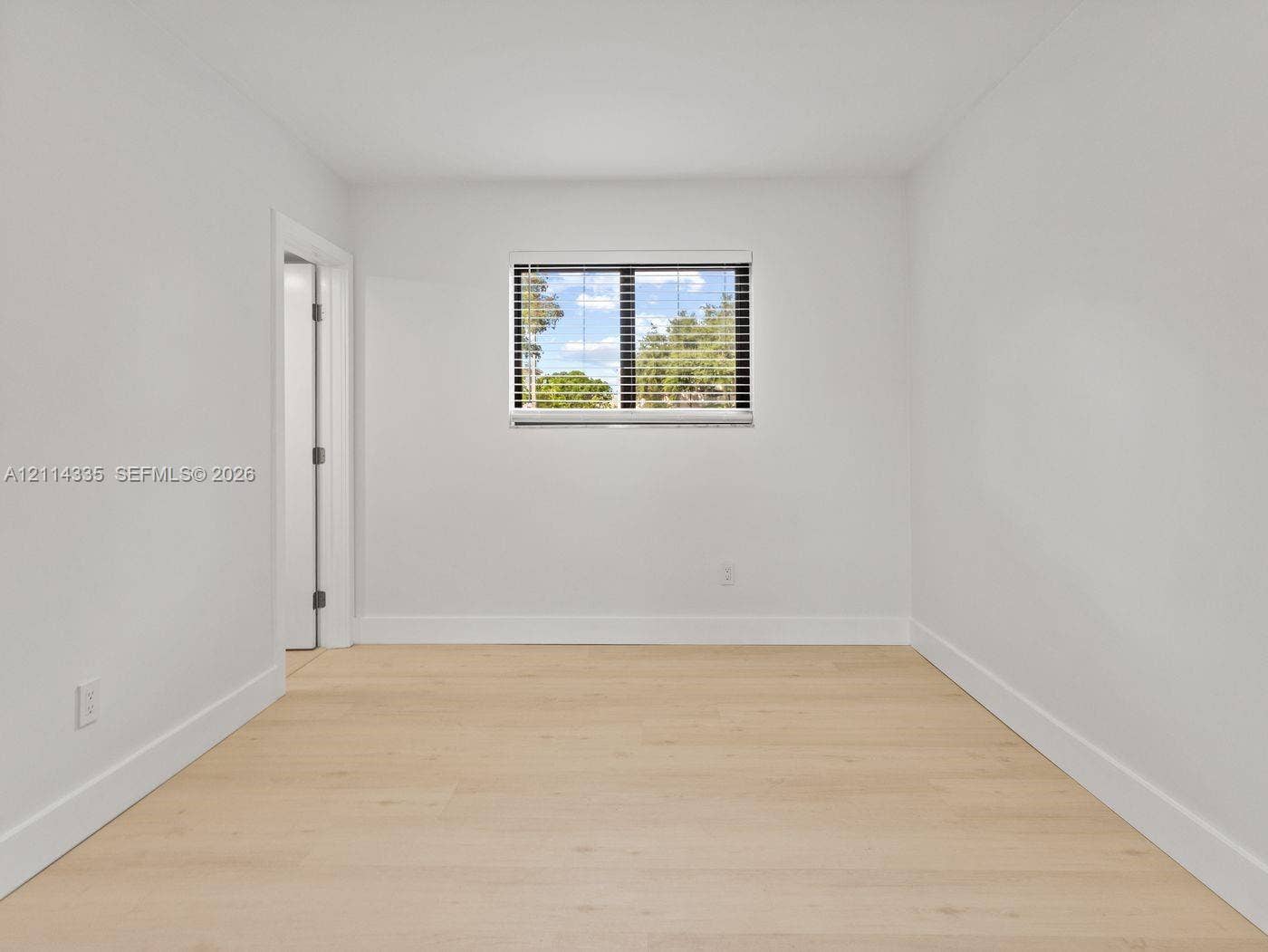 2930 Day Avenue, #N102, Miami, Miami, FL 33133 Interior space featuring wood-finish flooring, neutral walls, and a single-pane window with integrated blinds