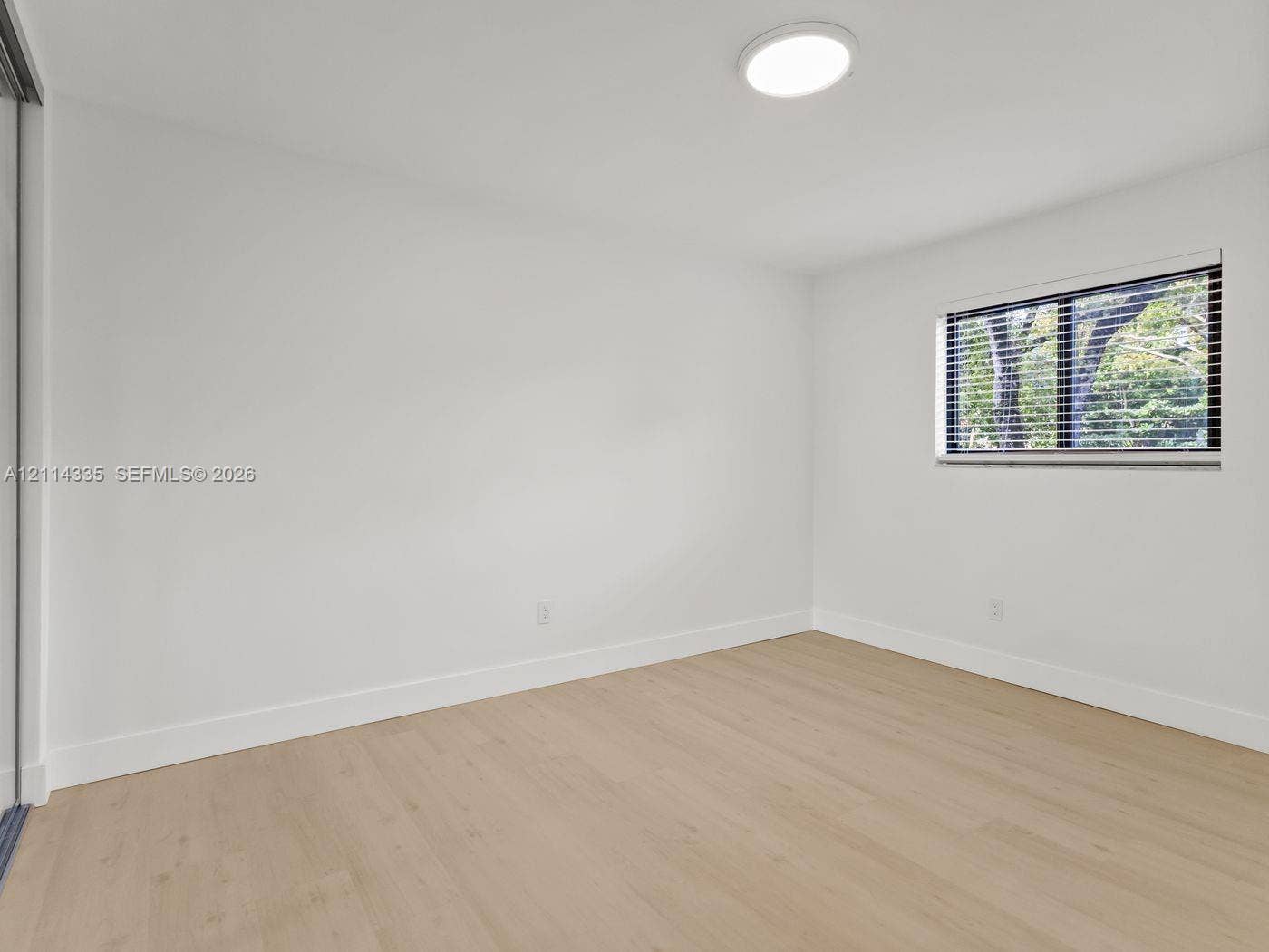 2930 Day Avenue, #N102, Miami, Miami, FL 33133 Interior space featuring wood-finish flooring, neutral walls, recessed LED lighting, and a window equipped with horizontal blinds